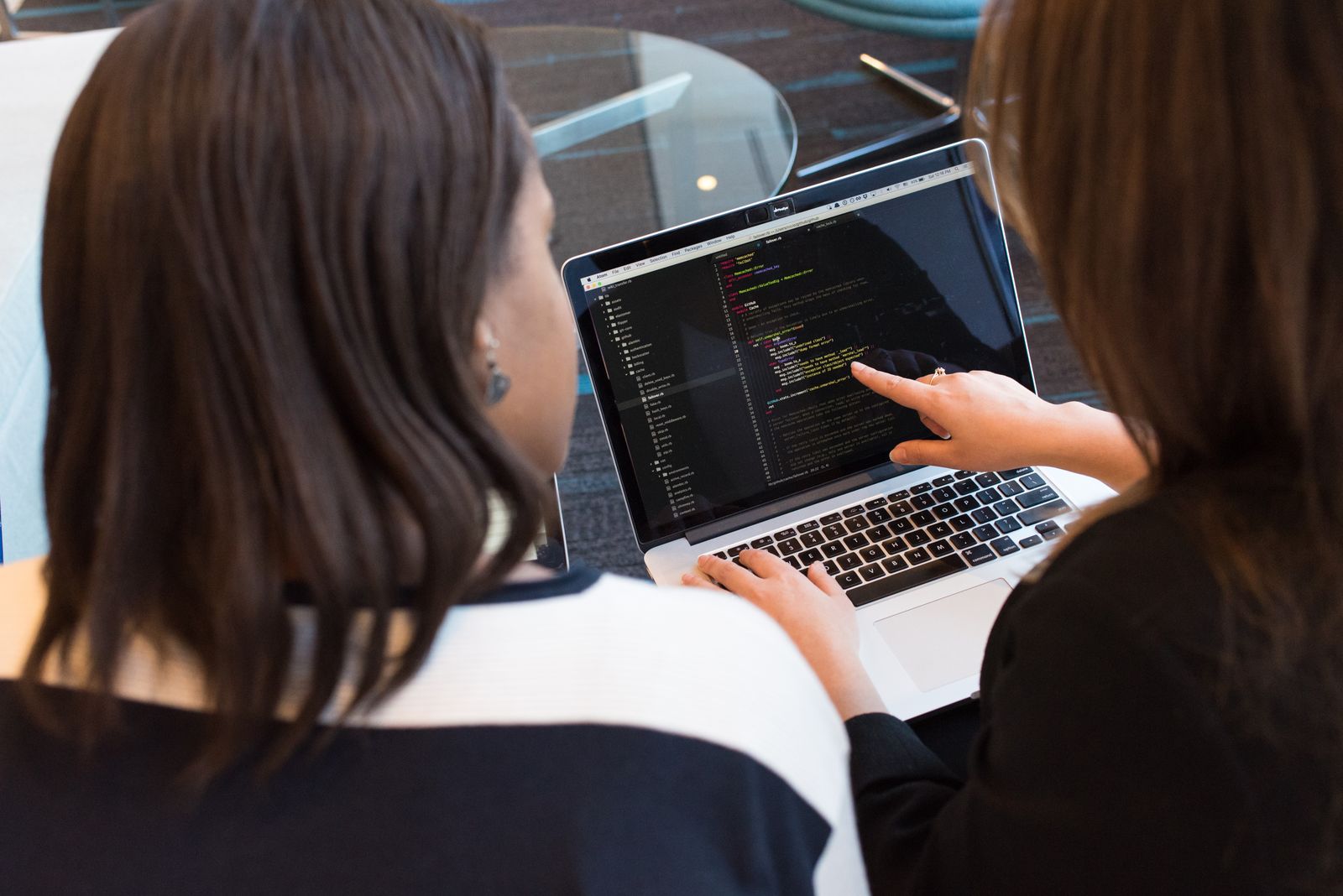 Two people working through code together at a laptop